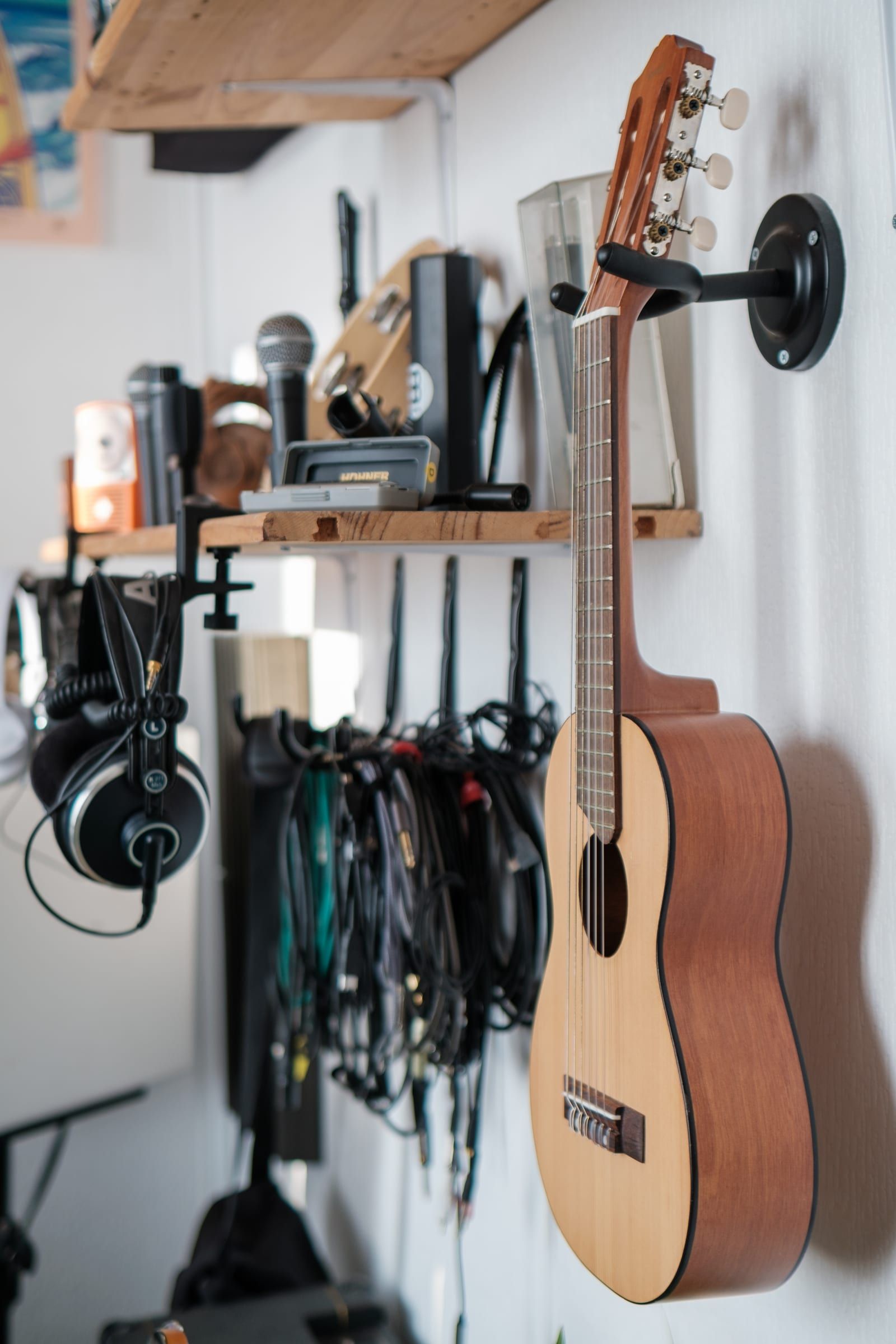 Mur du studio avec casques, câbles et guitare